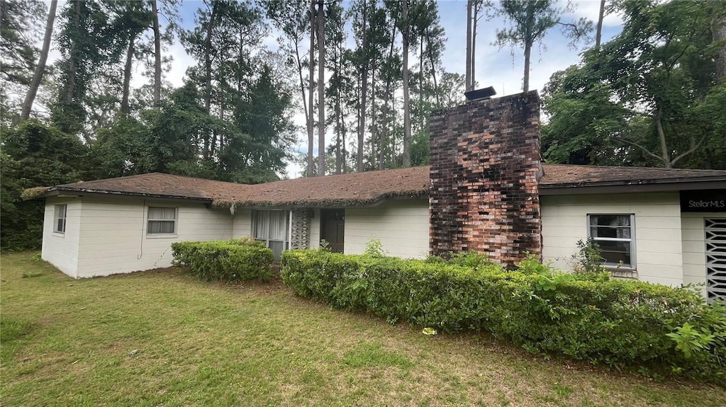 4985 NW 39th Ave, Gainesville, FL 32606 - rear view of house with a yard and a chimney