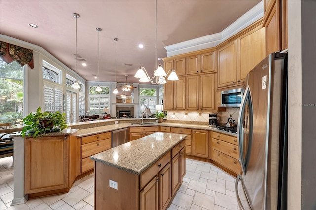 5025 NW 51st Pl, Gainesville, FL 32606 - kitchen with stainless steel appliances, a chandelier, a peninsula, backsplash, and a warm lit fireplace