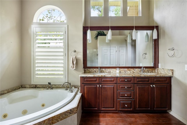 5025 NW 51st Pl, Gainesville, FL 32606 - full bathroom with plenty of natural light, double vanity, a jetted tub, and wood finished floors