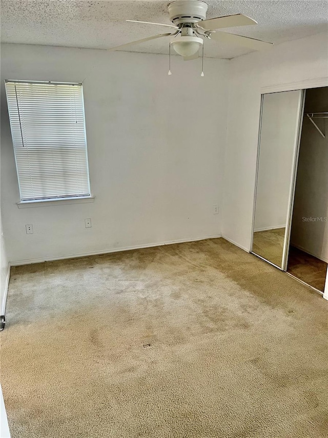 3705 SW 27th St Unit 1112, Gainesville, FL 32608 - unfurnished bedroom featuring carpet flooring, a textured ceiling, a closet, and ceiling fan