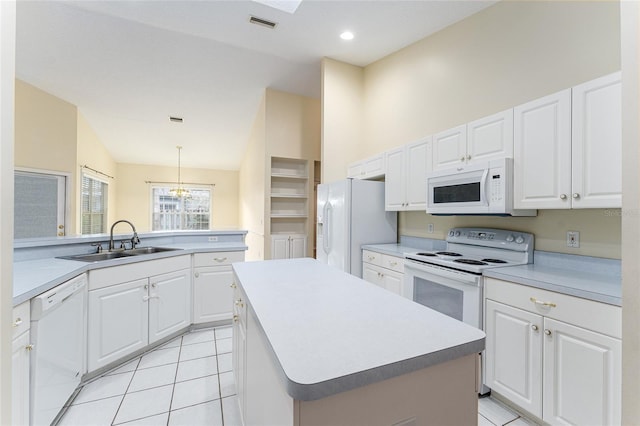 8036 SW 72nd Pl, Gainesville, FL 32608 - kitchen with white appliances, vaulted ceiling, light tile patterned floors, white cabinets, and a kitchen island