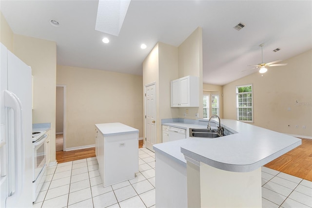 8036 SW 72nd Pl, Gainesville, FL 32608 - kitchen with a kitchen island, white appliances, light countertops, light tile patterned flooring, and a peninsula