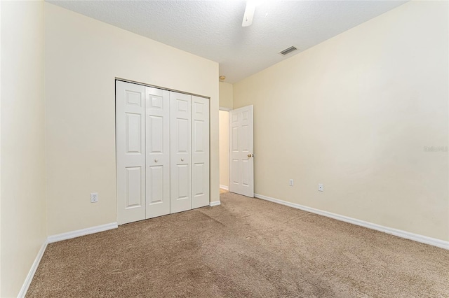 8036 SW 72nd Pl, Gainesville, FL 32608 - unfurnished bedroom featuring carpet floors, a closet, a textured ceiling, and a ceiling fan