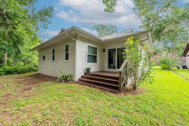 8488 NW 39th Ter, Gainesville, FL 32653 - rear view of house featuring stucco siding, a lawn, and a deck