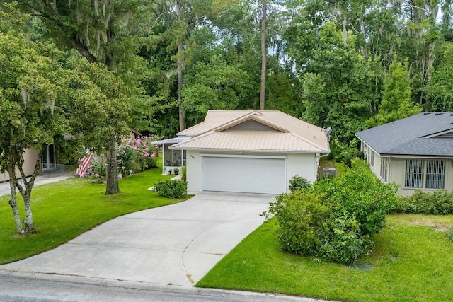 8488 NW 39th Ter, Gainesville, FL 32653 - view of front of home featuring driveway, a front yard, an attached garage, stucco siding, and a metal roof