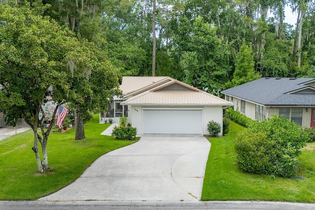 8488 NW 39th Ter, Gainesville, FL 32653 - view of front of property featuring driveway, a front lawn, an attached garage, a metal roof, and stucco siding