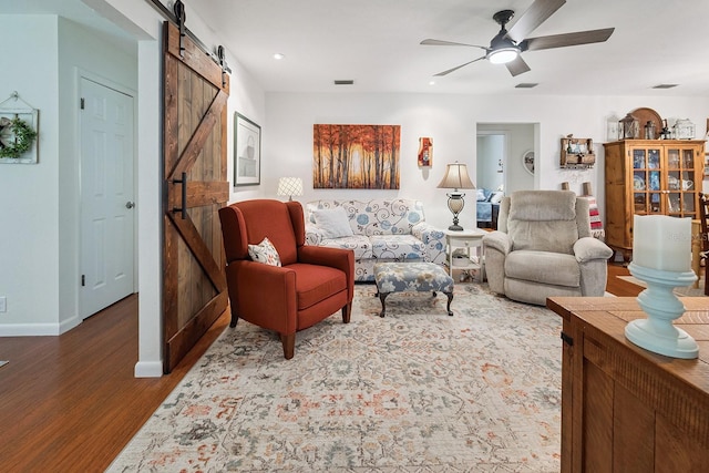 8488 NW 39th Ter, Gainesville, FL 32653 - living area featuring a barn door, wood finished floors, and a ceiling fan