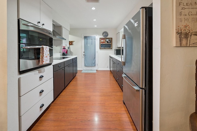 8488 NW 39th Ter, Gainesville, FL 32653 - kitchen with appliances with stainless steel finishes, light countertops, light wood-style floors, recessed lighting, and white cabinetry