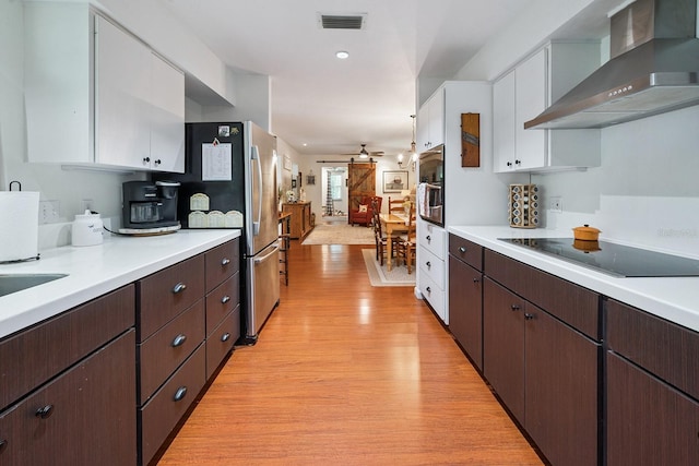 8488 NW 39th Ter, Gainesville, FL 32653 - kitchen featuring wall chimney exhaust hood, appliances with stainless steel finishes, light wood-type flooring, white cabinets, and light countertops
