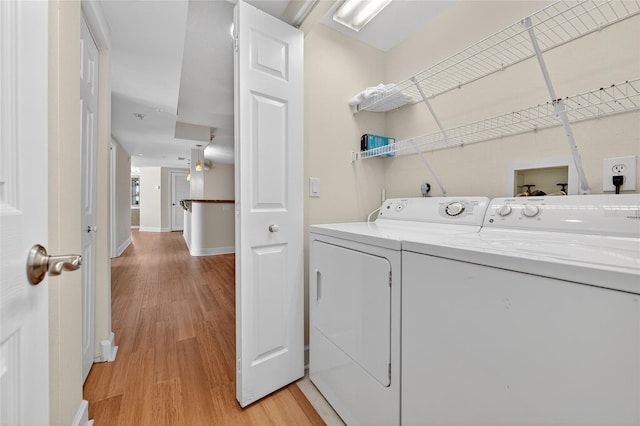 4555 S Atlantic Ave Unit 4603, Ponce Inlet, FL 32127 - washroom with washing machine and dryer and light wood-style flooring