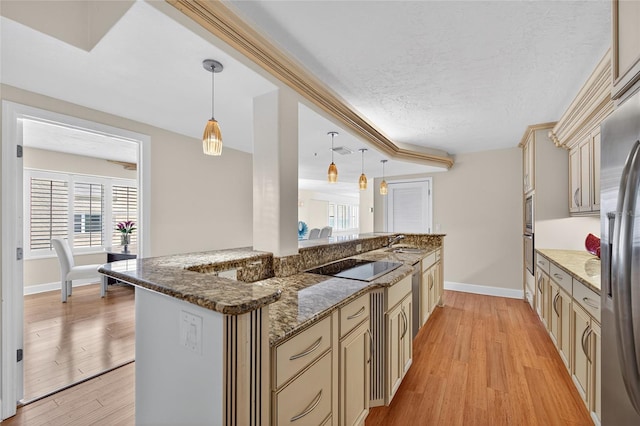 4555 S Atlantic Ave Unit 4603, Ponce Inlet, FL 32127 - kitchen with cream cabinetry, light wood-style flooring, plenty of natural light, and a textured ceiling