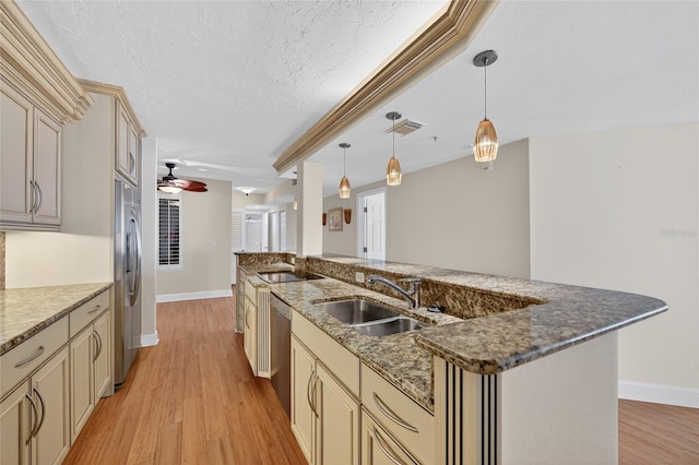4555 S Atlantic Ave Unit 4603, Ponce Inlet, FL 32127 - kitchen featuring cream cabinets, ceiling fan, light wood-style floors, a textured ceiling, and appliances with stainless steel finishes
