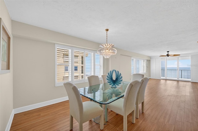 4555 S Atlantic Ave Unit 4603, Ponce Inlet, FL 32127 - dining room featuring a chandelier, a textured ceiling, wood finished floors, and a water view