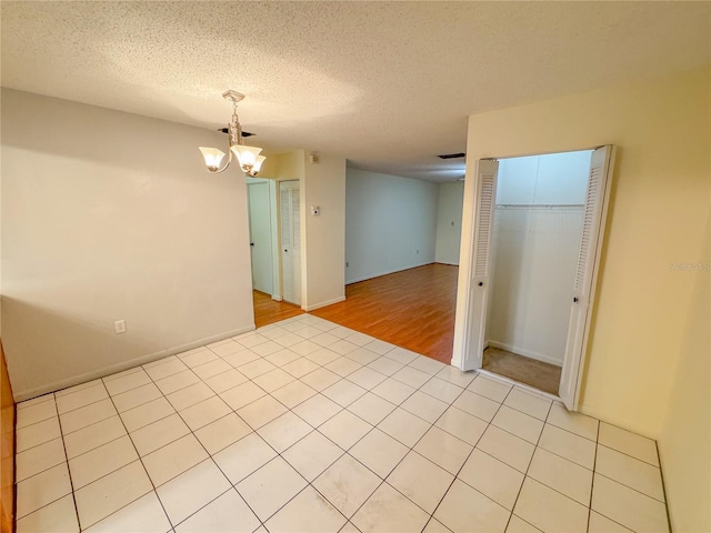 2710 SW 14th Dr, Gainesville, FL 32608 - empty room featuring a chandelier, a textured ceiling, and light tile patterned floors