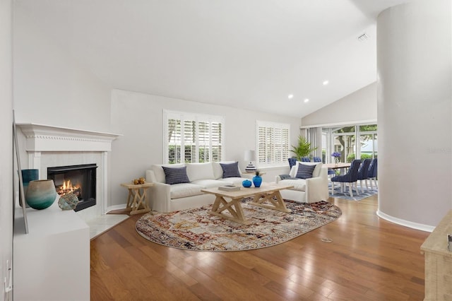 10549 NW 32nd Rd, Gainesville, FL 32606 - living area featuring hardwood / wood-style floors, a tiled fireplace, healthy amount of natural light, high vaulted ceiling, and recessed lighting