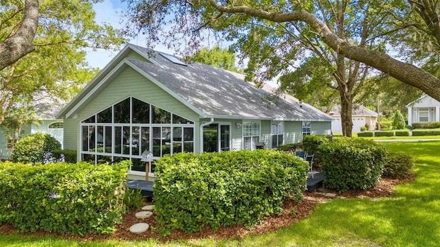 10549 NW 32nd Rd, Gainesville, FL 32606 - rear view of house with a sunroom and a lawn