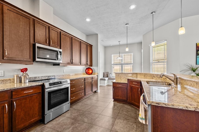 2750 NW 143rd Way, Newberry, FL 32669 - kitchen featuring appliances with stainless steel finishes, decorative light fixtures, light stone countertops, dark tile patterned flooring, and recessed lighting