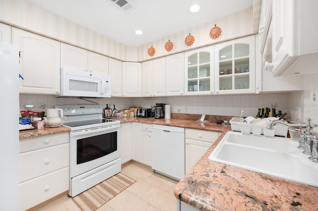4705 SW 80th Ter, Gainesville, FL 32608 - kitchen featuring white appliances, light tile patterned floors, decorative backsplash, white cabinetry, and glass insert cabinets