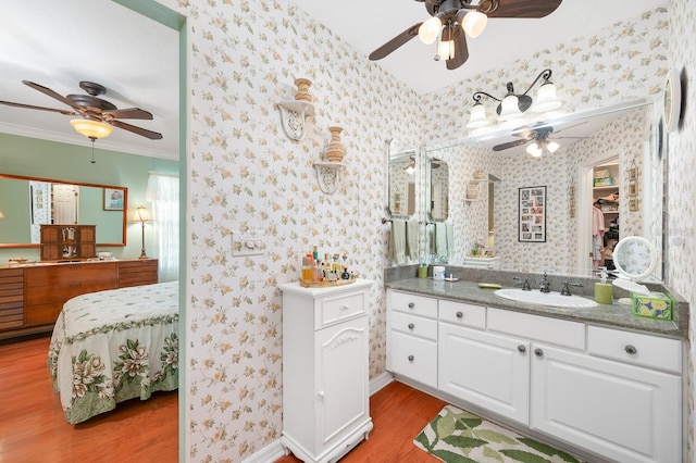 4705 SW 80th Ter, Gainesville, FL 32608 - bathroom featuring ceiling fan, wood finished floors, vanity, wallpapered walls, and crown molding