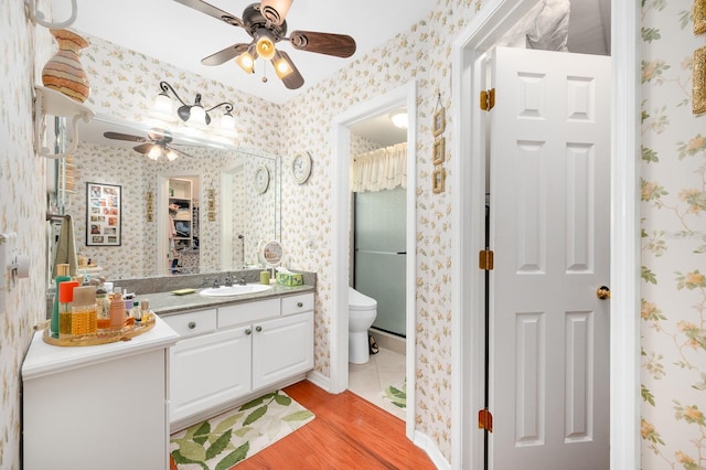 4705 SW 80th Ter, Gainesville, FL 32608 - bathroom with ceiling fan, vanity, wood finished floors, wallpapered walls, and a closet