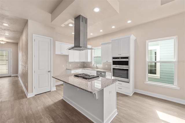 1080 NW 132nd Blvd, Newberry, FL 32669 - kitchen featuring island exhaust hood, stainless steel appliances, a center island, white cabinetry, and light stone counters