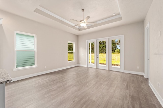 1080 NW 132nd Blvd, Newberry, FL 32669 - empty room with a tray ceiling, light wood finished floors, and a ceiling fan