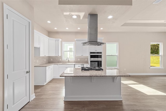 1080 NW 132nd Blvd, Newberry, FL 32669 - kitchen with island range hood, a center island, white cabinetry, light stone counters, and recessed lighting