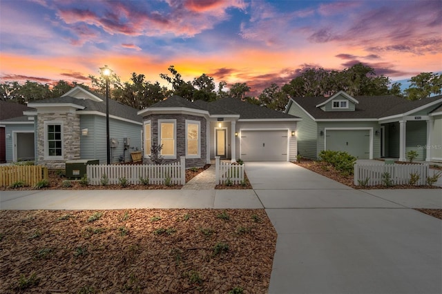 1080 NW 132nd Blvd, Newberry, FL 32669 - view of front of home with driveway, stone siding, a garage, and a fenced front yard