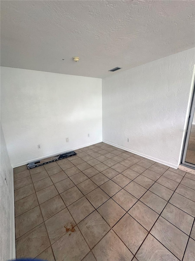 1215 NE 21st Ave, Gainesville, FL 32609 - spare room featuring a textured ceiling and tile patterned flooring