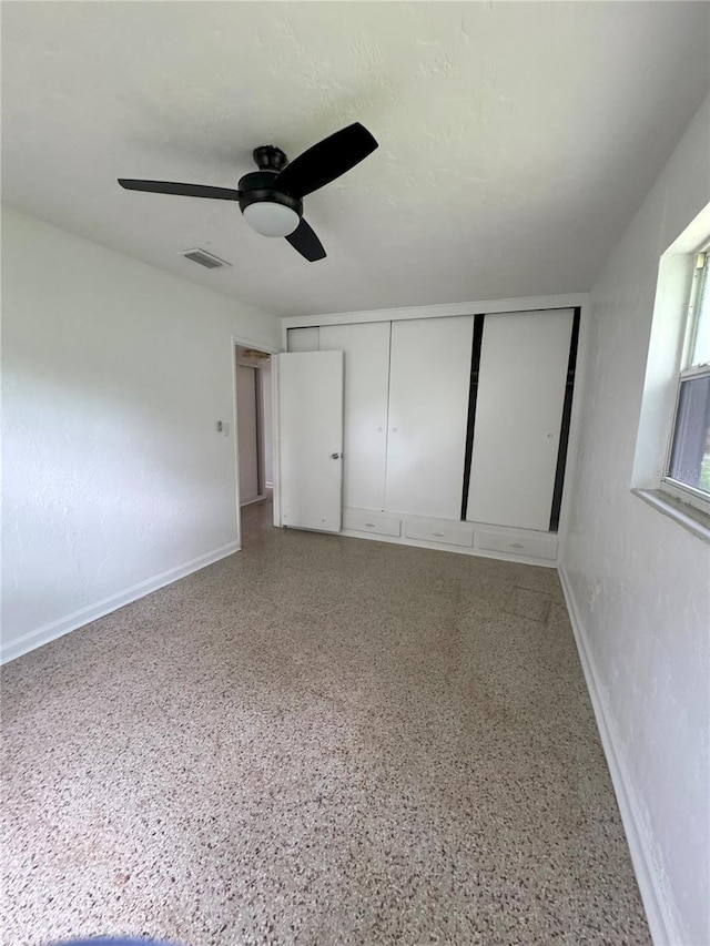 1215 NE 21st Ave, Gainesville, FL 32609 - unfurnished bedroom with speckle patterned floor, ceiling fan, and a closet