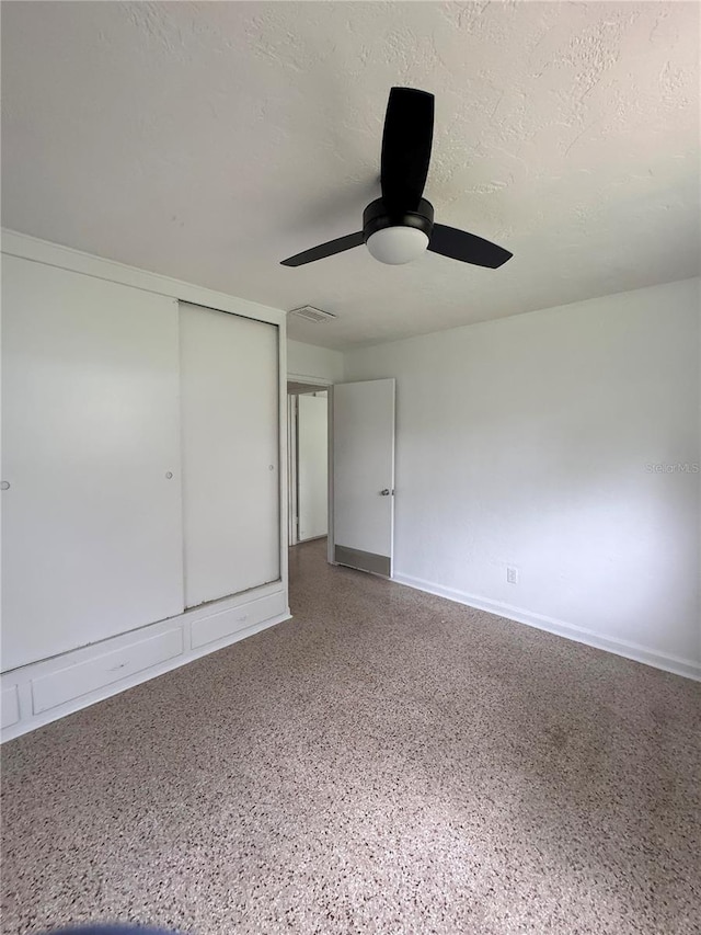 1215 NE 21st Ave, Gainesville, FL 32609 - unfurnished bedroom featuring a closet, speckled floor, ceiling fan, and a textured ceiling