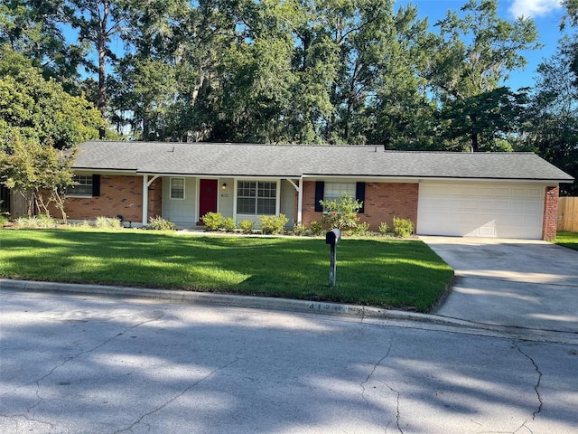 4121 NW 15th Pl, Gainesville, FL 32605 - ranch-style house with driveway, a garage, a front lawn, and brick siding