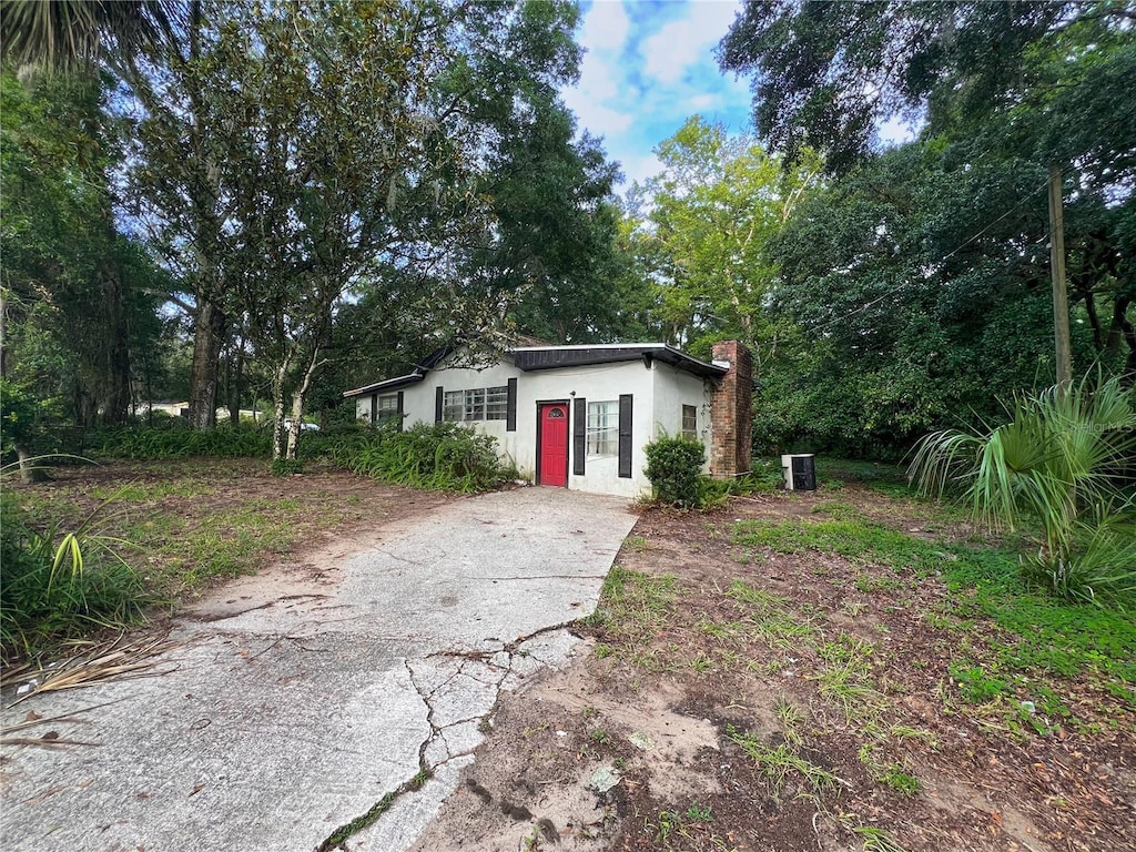 1402 SE 27th St, Gainesville, FL 32641 - bungalow-style house with stucco siding, concrete driveway, and a chimney