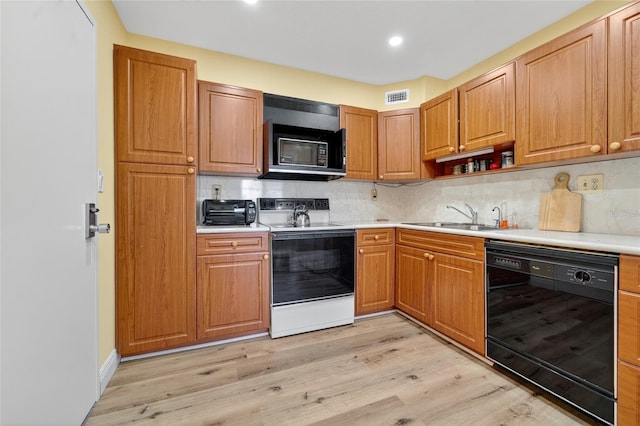 10777 W Sample Rd Unit 1212, Coral Springs, FL 33065 - kitchen featuring black appliances, light wood-style flooring, light countertops, backsplash, and recessed lighting