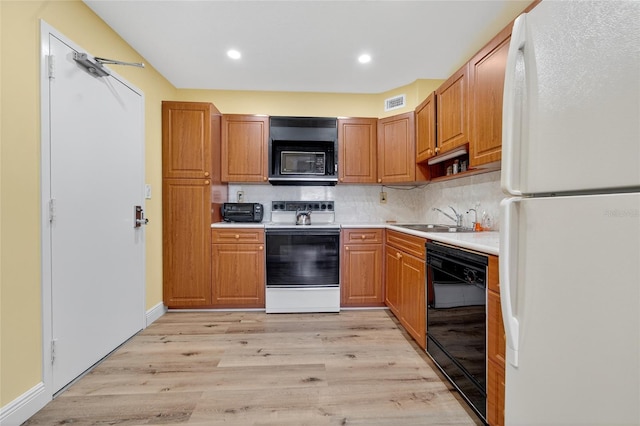 10777 W Sample Rd Unit 1212, Coral Springs, FL 33065 - kitchen with black appliances, light countertops, light wood finished floors, decorative backsplash, and recessed lighting