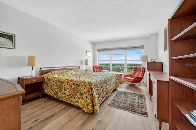 10777 W Sample Rd Unit 1212, Coral Springs, FL 33065 - bedroom featuring light wood finished floors and a textured ceiling