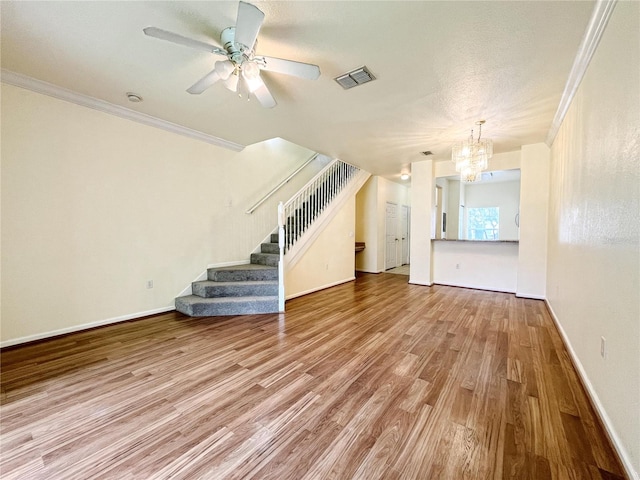 4877 NW 42nd Rd Unit 106, Gainesville, FL 32606 - unfurnished living room featuring a chandelier, stairway, wood finished floors, crown molding, and ceiling fan