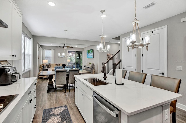 kitchen featuring visible vents, a notable chandelier, dishwasher, a sink, and light wood-style flooring