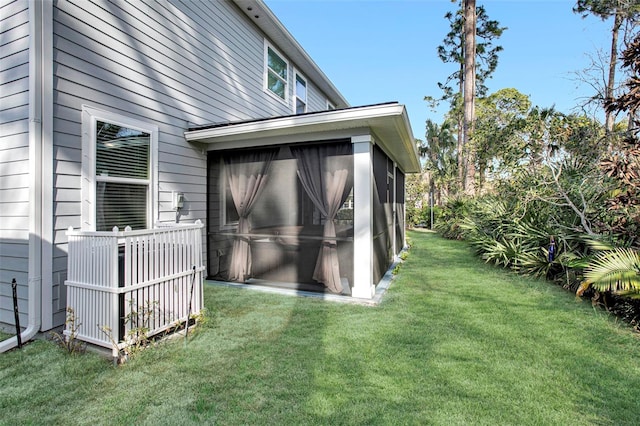 exterior space featuring a sunroom and a lawn
