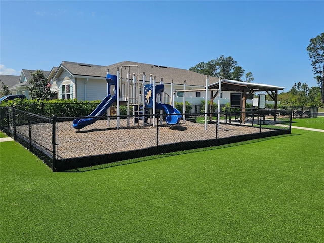 community play area featuring fence and a lawn