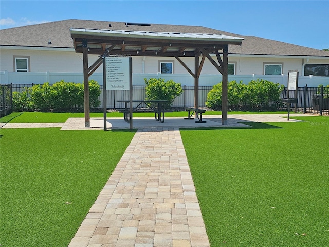 view of home's community with fence and a lawn
