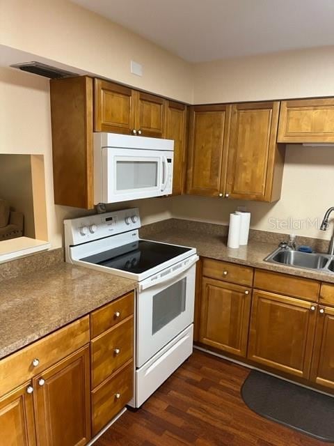 kitchen featuring dark hardwood / wood-style floors, white appliances, and sink