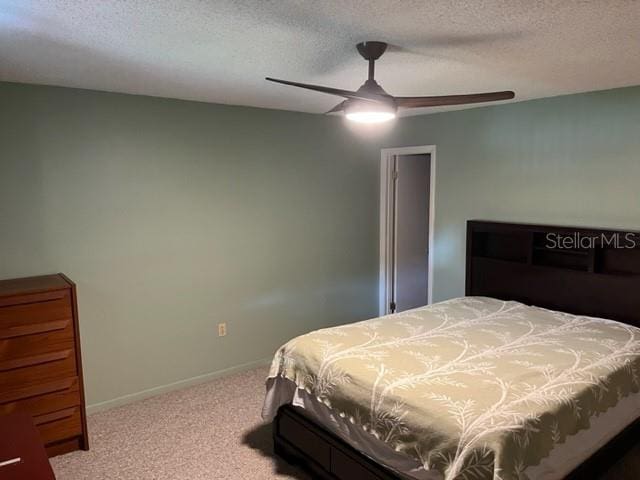 carpeted bedroom with a textured ceiling and ceiling fan