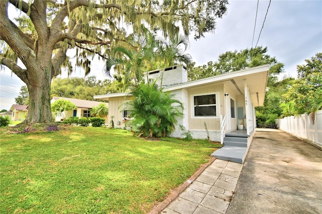 view of front of property featuring a front yard, fence, and a chimney