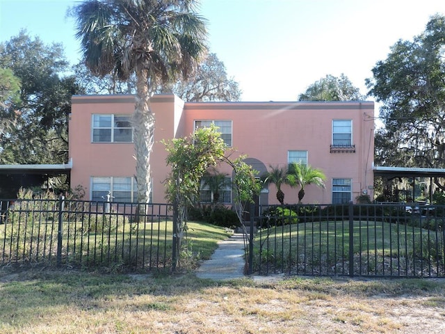 view of front of home with a carport and a front lawn