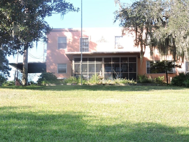 back of house with a sunroom and a yard