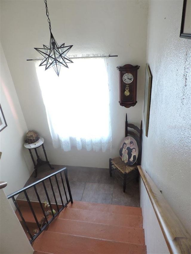 stairs featuring a chandelier