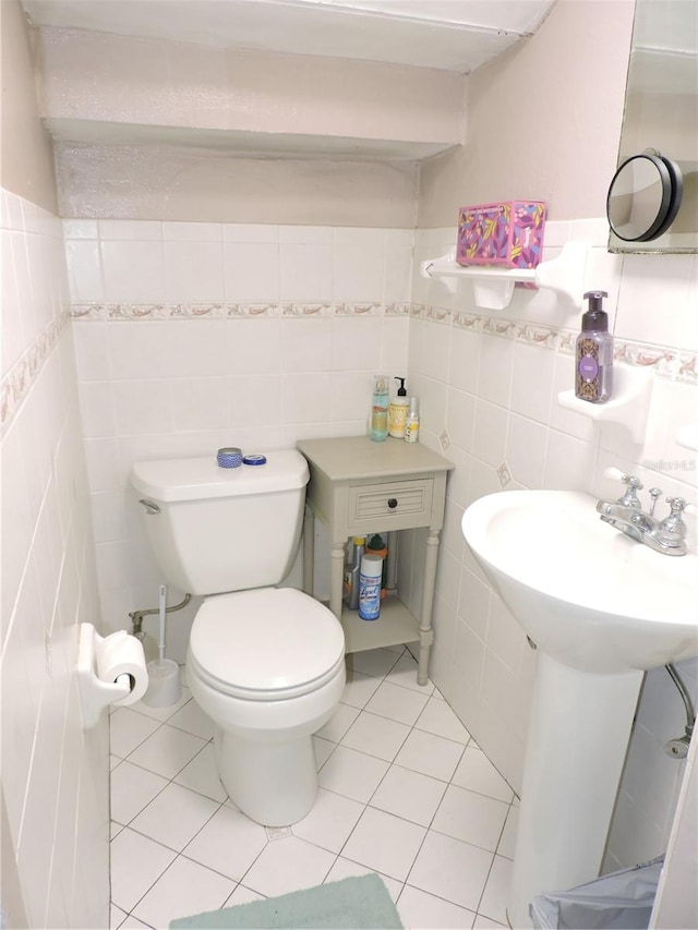 bathroom featuring tile patterned flooring, toilet, and tile walls