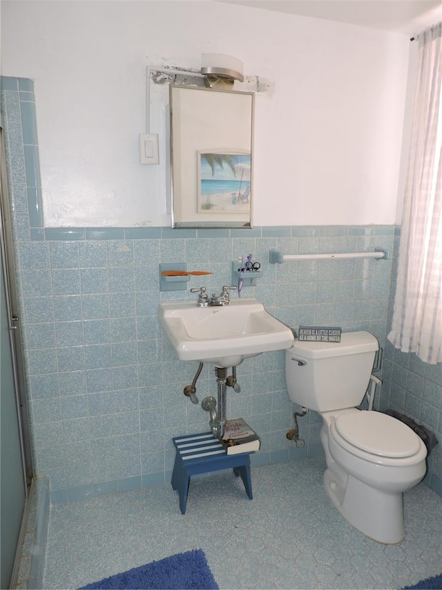 bathroom with tile walls, sink, and toilet