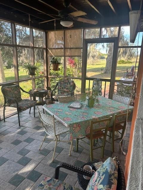 sunroom / solarium with a healthy amount of sunlight and ceiling fan